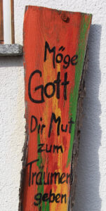 Stele mit Spruch vor dem Haus